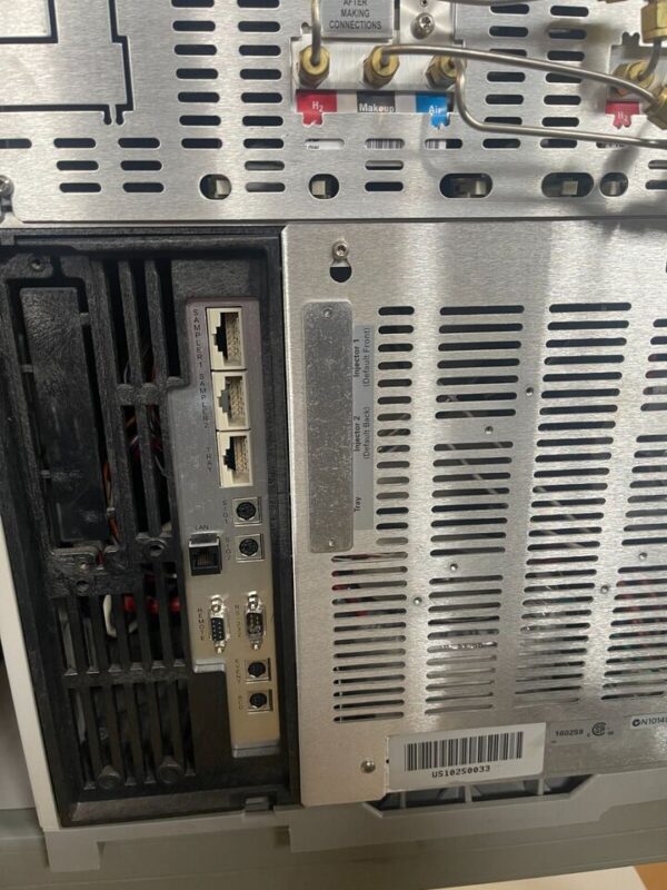 Backside of a grey metal machine with many ports.